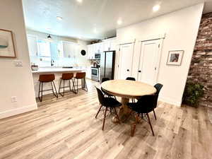 Dining room featuring a textured ceiling, light wood finished floors, and recessed lighting
