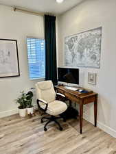 Office space featuring light wood-style floors and a textured ceiling