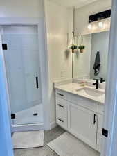 Full bathroom with vanity and a shower stall