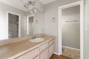 Primary bathroom with vanity and dark wood-type flooring