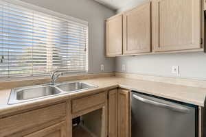 Kitchen featuring dishwasher, light countertops, and light brown cabinets