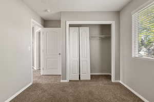 Unfurnished bedroom featuring carpet flooring and a closet