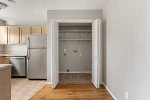 Laundry room with tile floors, a textured ceiling, washer hookup, and electric dryer hookup