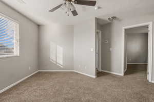 Unfurnished bedroom with carpet floors, a textured ceiling, and a ceiling fan