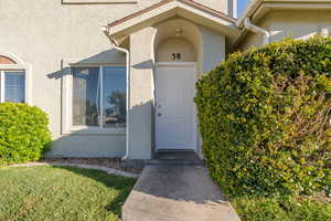 View of exterior entry with stucco siding