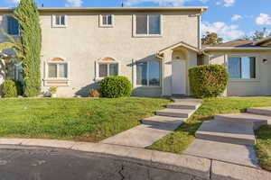 View of front facade featuring stucco siding and a front yard