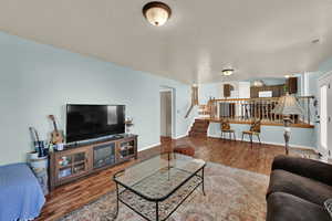 Living area with wood finished floors and stairway
