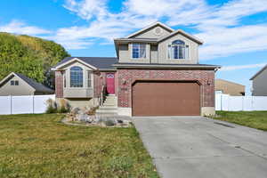 View of front facade with concrete driveway, a garage, brick siding, and stucco siding