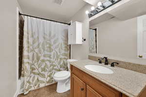 Full bath with vanity, dark tile patterned floors, and shower / bathtub combination with curtain