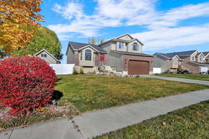 View of front facade with brick siding, concrete driveway, a garage, and stucco siding