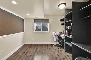 Office featuring light wood-style floors, built in study area, and recessed lighting
