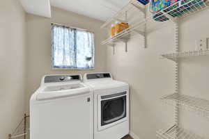 Laundry area featuring washing machine and dryer and baseboards