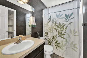 Full bathroom featuring curtained shower, vanity, and dark wood finished floors