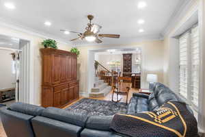 Living area with ornamental molding, ceiling fan, a chandelier, recessed lighting, and light wood finished floors