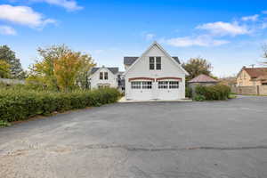 View of side of home featuring a garage, asphalt driveway, and stucco siding