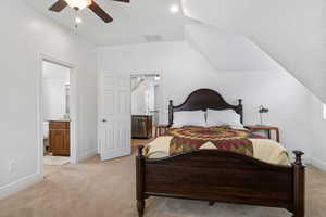 Bedroom featuring light colored carpet, connected bathroom, vaulted ceiling, ceiling fan, and recessed lighting