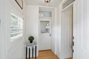 Entryway featuring wood finished floors and a chandelier