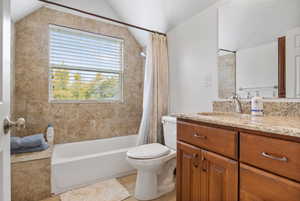 Full bathroom featuring vanity, shower / tub combo with curtain, and lofted ceiling