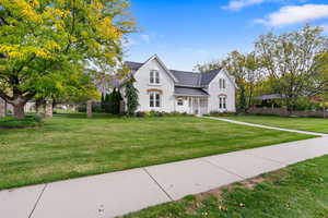 View of front facade with covered porch, stucco siding, and roof with shingles