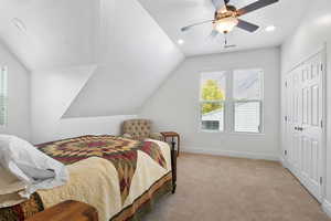 Carpeted bedroom with recessed lighting, a ceiling fan, vaulted ceiling, and a closet