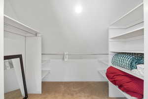 Spacious closet featuring light colored carpet