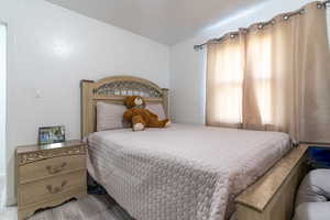 Bedroom featuring light wood finished floors and a textured wall