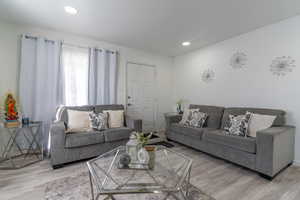 Living room with wood finished floors and recessed lighting