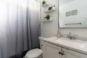 Full bath with a shower with shower curtain, vanity, and a textured wall