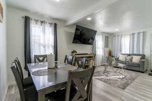 Dining room featuring light wood-type flooring, beamed ceiling, and recessed lighting
