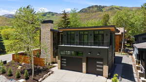 Contemporary exterior featuring dark paneling, a prominent stone-clad chimney, and a flat roofline