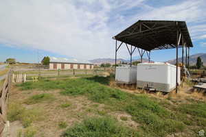 View of yard with a mountain view, a rural view, and an outdoor structure