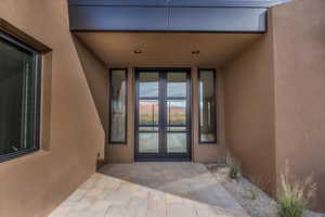 Doorway to property with french doors, a patio, and stucco siding