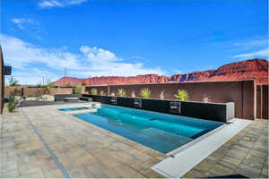 Integrated pool / hot tub featuring a fenced backyard, a mountain view, and a patio area
