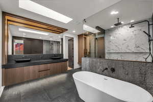 Full bathroom featuring a marble finish shower, double vanity, a freestanding tub, tile walls, and recessed lighting