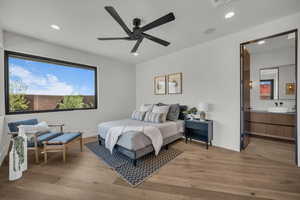 Bedroom featuring light wood-style floors, a ceiling fan, recessed lighting, and connected bathroom