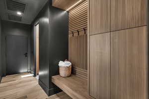 Mudroom with light wood finished floors and recessed lighting