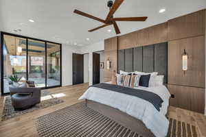 Bedroom featuring light wood-style flooring, expansive windows, access to exterior, ceiling fan, and recessed lighting