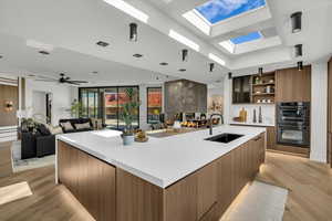 Kitchen with wood finish cabinetry, modern cabinets, open floor plan, and a spacious island