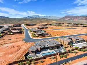 Aerial perspective of suburban area featuring a mountain backdrop and a desert landscape
