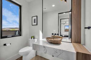 Ensuite bathroom with vanity, wood finished floors, and recessed lighting