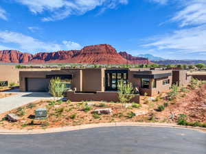 Adobe home with stucco siding, a mountain view, driveway, and an attached garage