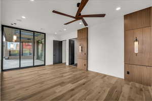 Unfurnished bedroom with light wood-style flooring, a wall of windows, ceiling fan, recessed lighting, and access to outside