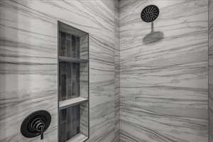 Full bathroom with a marble finish shower