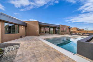 View of pool with a patio area and an in-ground hot tub