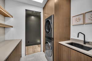 Laundry room featuring a sink and stacked washer / drying machine