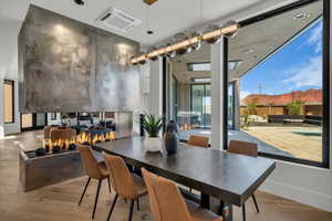 Dining room featuring light wood-style floors, a mountain view, recessed lighting, and expansive windows