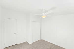Unfurnished bedroom featuring carpet, ceiling fan, and a closet