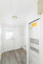 Laundry room with a heating unit and light wood finished floors