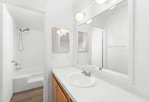 Full bath featuring vanity, shower / washtub combination, and dark wood finished floors