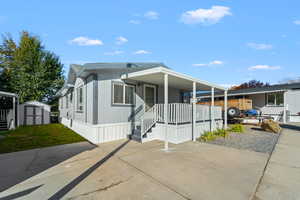 Manufactured / mobile home with a storage shed and covered porch